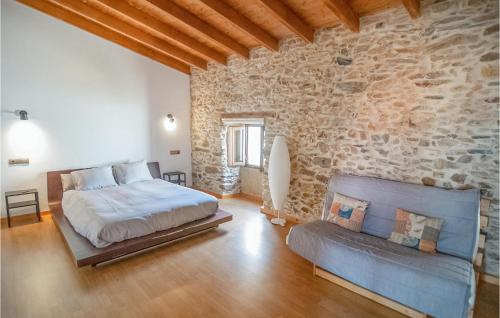 绍塞列Stunning Home In Saucelle With Kitchen的一间卧室设有一张床和石墙