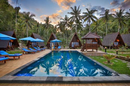 珀尼达岛Mahaloka Valley Nusa Penida的一个带游泳池、椅子和棕榈树的度假村