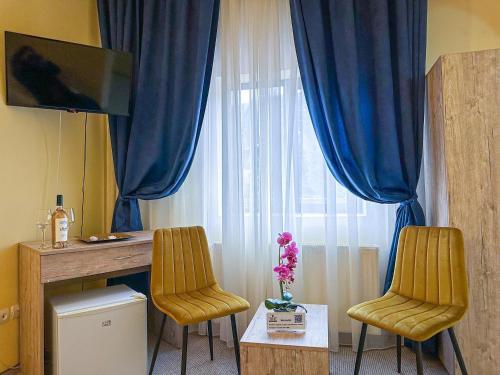 阿祖加Hotel Pin Azuga的窗户客房内的两把椅子和一张桌子