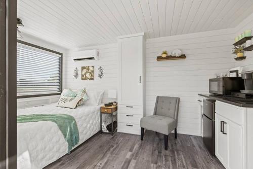 弗雷德里克斯堡New Wilderness Hideout-Cozy Container Home的白色卧室配有床和椅子