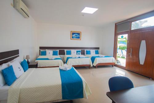 巴克里索莫雷诺港Blue Marlin Hotel的酒店客房设有四张床和窗户。