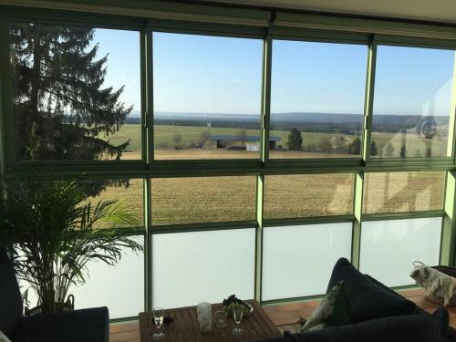 勒芬根Gemütliches Apartment mit wundervollem Weitblick的客房设有大窗户,享有田野美景。