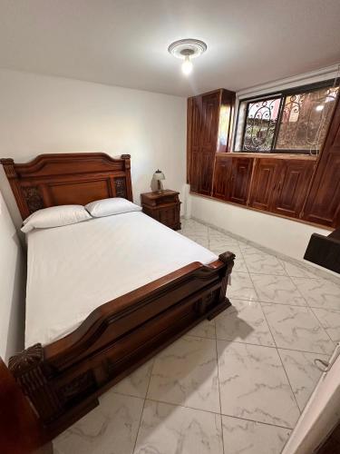 麦德林Acogedor apartamento cerca al centro de Medellin的一间卧室设有一张大床和一个窗户。