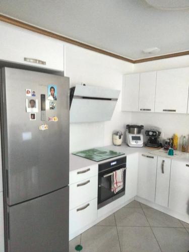 鲁贝勒斯Bulle d oxygène的厨房配有不锈钢冰箱和白色橱柜