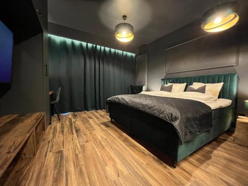 卡托维兹Apartament Manhattan Premium - I-wsza Dzielnica - by Kairos Apartments的一间卧室设有一张大床,铺有木地板