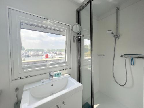 KerkdrielRoermond的带淋浴和盥洗盆的浴室以及窗户。