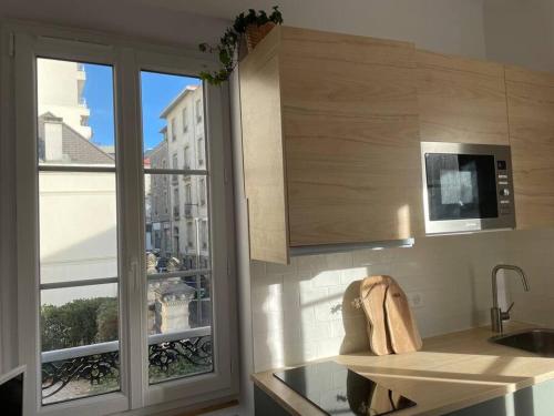 比亚里茨Studio Biarritz 2 min Halles, 3 min plages, plein centre.的厨房配有水槽、微波炉和窗户