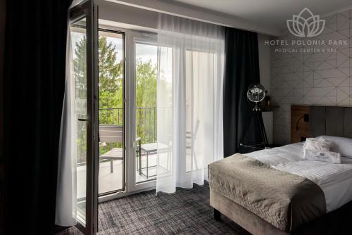 布斯克·兹德鲁伊Hotel Polonia PARK Medical Center & Spa的酒店客房设有一张床和一个阳台。