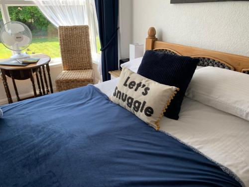 佩恩顿Bella Vista的一张带蓝色毯子和枕头的床,上面写着唤醒