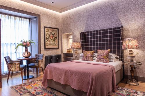 爱丁堡雷布恩酒店的一间卧室配有一张床和一张桌子及椅子