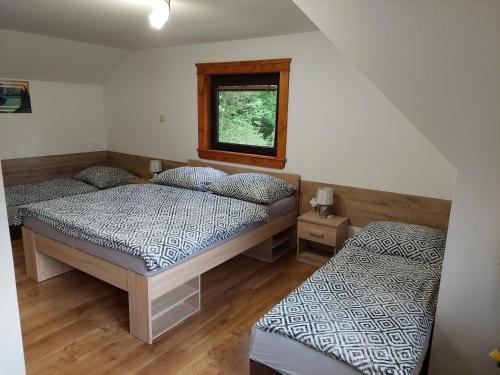 特尔乔夫Chata u Michala- neakceptujeme mladé partie的一间卧室设有两张床和窗户。