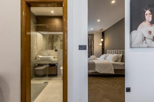 斯普利特Luxury rooms Bolero的一间卧室和一间带床和镜子的浴室