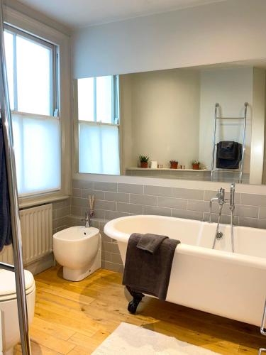 伦敦Home in Chiswick Homefields的浴室配有白色浴缸和卫生间。