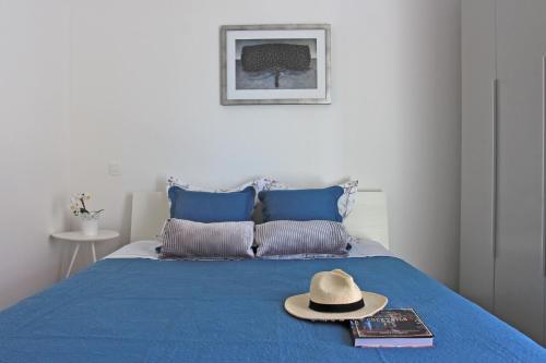 苏提万Apartment Limoni的蓝色床上的帽子和书籍