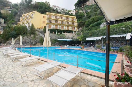 波西塔诺Luxury Suite Royal Positano的一个带躺椅的游泳池和一间酒店