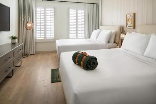 圣巴巴拉The Steward, Santa Barbara, a Tribute Portfolio Hotel的酒店客房,配有两张床和睡袋