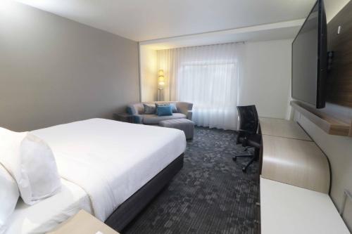 蒙特雷蒙特雷机场万怡酒店 的酒店客房,配有床和沙发
