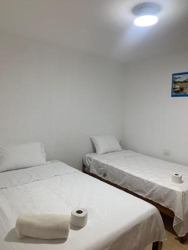 BocapánBOCARENA的白色墙壁客房的两张床