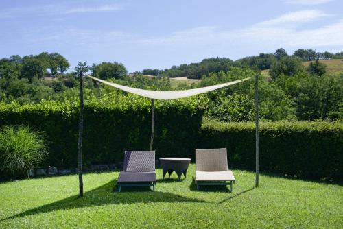 Belforte del ChientiCoroncina的草上两把椅子和一张桌子,有帐篷