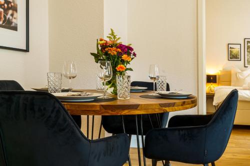 什未林Suite für 4 mit Terrasse im Herzen der Innenstadt的餐桌、椅子和花瓶