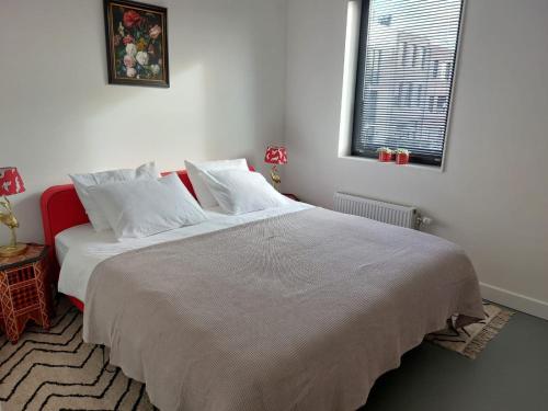 阿纳姆Medina B&B hartje Arnhem的卧室配有一张带白色床单的大床和窗户。