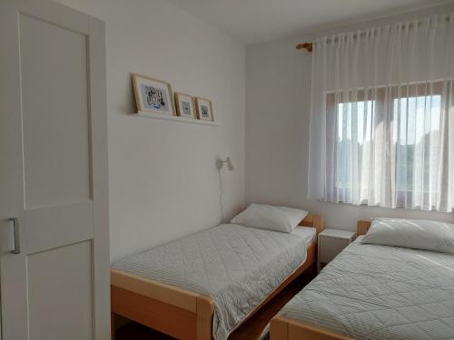 维拉斯奇Apartments Vlasici的小房间设有两张床和窗户