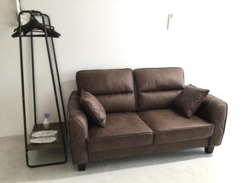 宫崎Accommodation Service - Vacation STAY 43779v的客厅里一张棕色的沙发,配有灯