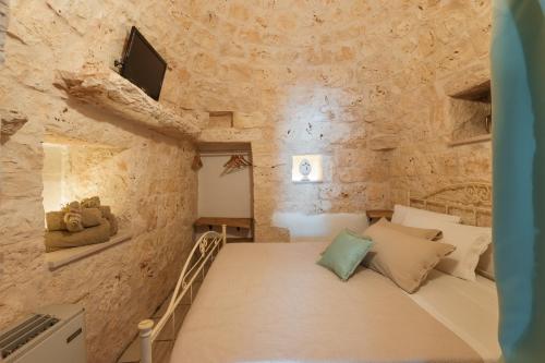 圣维托诺曼Trulli Olea的卧室配有一张石墙床