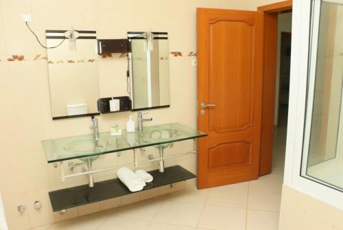 Cidade VelhaCidade Paradise Guesthouse的一间带玻璃水槽和镜子的浴室