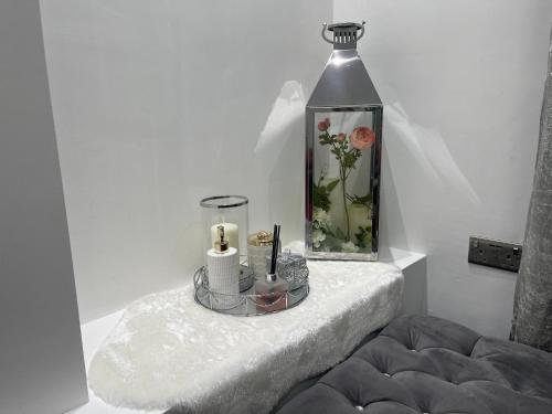 曼彻斯特Luxury Holiday Home的一间设有一张桌子的房间,里面放着花瓶和蜡烛