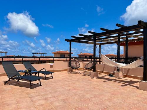 拉哈雷斯Villa Aloe的一个带椅子和吊床的屋顶庭院