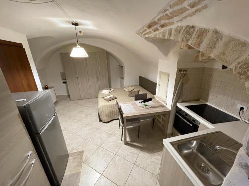 普蒂尼亚诺Il Segreto的厨房以及带桌子和冰箱的客厅。