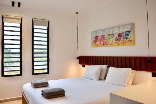 Dorp Sint MichielBlue Bay Penthouse REEF 5, BEACH GOLF POOL DIVE with OCEAN View的一间卧室设有两张床和两个窗户。