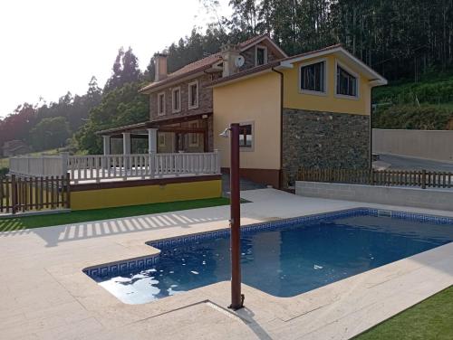 塞代拉Casa rural con piscina, Cedeira, San Román的房屋前有游泳池的房子