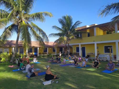 普拉杜Quintal da Praia的一群人在建筑物的院子里做瑜伽