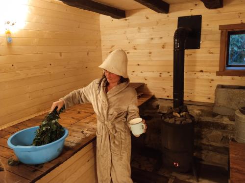 埃伦娜Balkan Mountains Villa Spa的一位身处小屋的女士,有一桶绿色植物