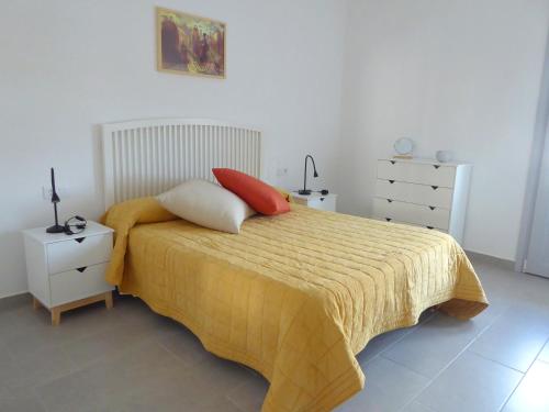 蒂约那La casa rosada (The pink house)的一间卧室配有一张带黄毯和两个枕头的床