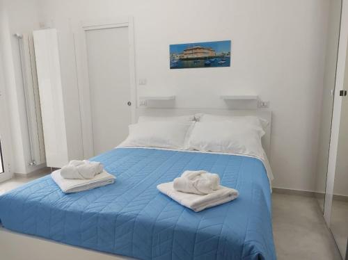 巴里Mare Luna Apartment的一间卧室配有蓝色的床和毛巾