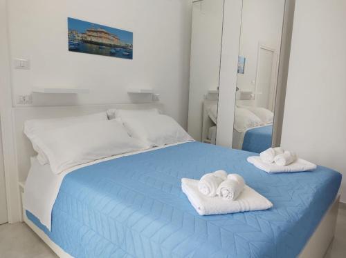 巴里Mare Luna Apartment的一间卧室配有蓝色的床和毛巾