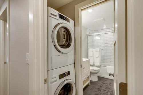 斯托Owls' Nest的浴室设有洗衣机和烘干机,位于厕所旁