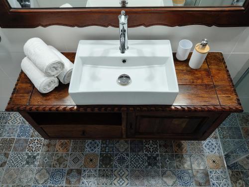 阿波罗尼亚Casa Centrale的浴室水槽位于木桌旁,配有毛巾