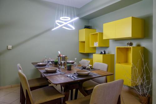 纳夫普利翁La Perla di Nafplio - La Diva di Nafplio - 2 VIP Villas的用餐室配有木桌和黄色橱柜
