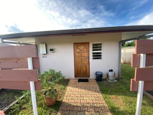 TaravaoJorsen House Tahiti 2 : bungalow confortable的一间白色的小房子,设有木门