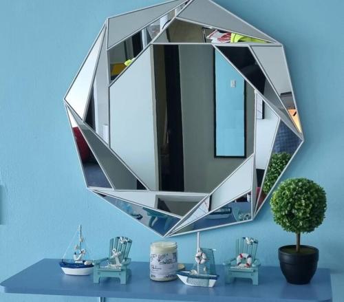 普拉亚科罗纳多Hermoso apartamento de Playa en Coronado的蓝色墙上的镜子,带蓝色桌子