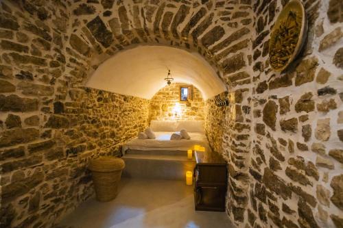 科帕罗Villa Porta Qeparo的卧室配有一张石墙床