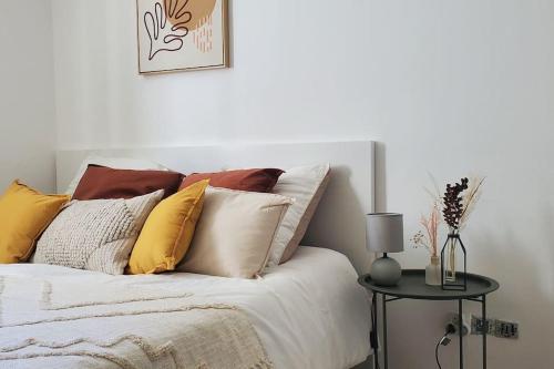 OsnyTulsa Home - Appartement 2 chambres, Charmant et moderne avec terrasse privée的一间卧室配有一张带枕头和桌子的床
