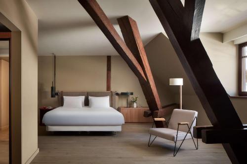 海德堡NH Collection Heidelberg的卧室配有白色的床和椅子