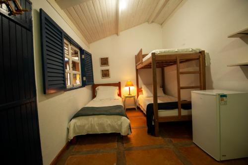 帕萨夸特鲁Chalés Del'Minas的小房间设有两张床和窗户