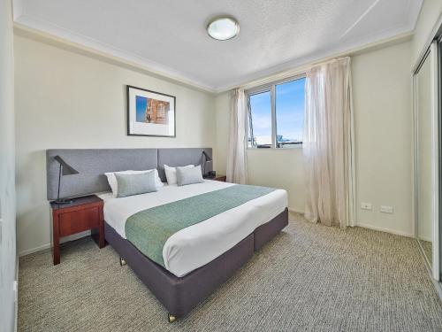 布里斯班奎斯特早餐小溪酒店的一间卧室设有一张大床和一个窗户。