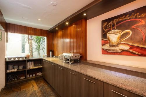 特鲁希略Hotel Country Trujillo的厨房壁上挂着咖啡杯的大画